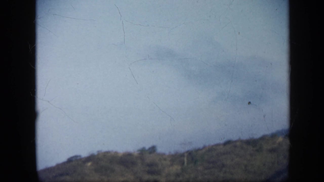 End frame from the 1959 Venezuela clip showing pale sky, a sloped ridge, and visible scratches in the 8mm scan.