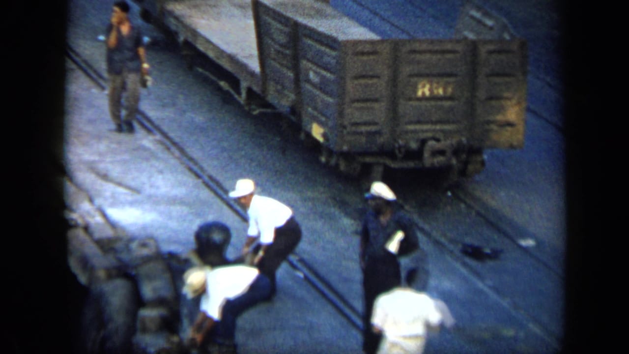Elevated 8mm view of men working around freight cars and rail lines in a Venezuelan yard in 1959.