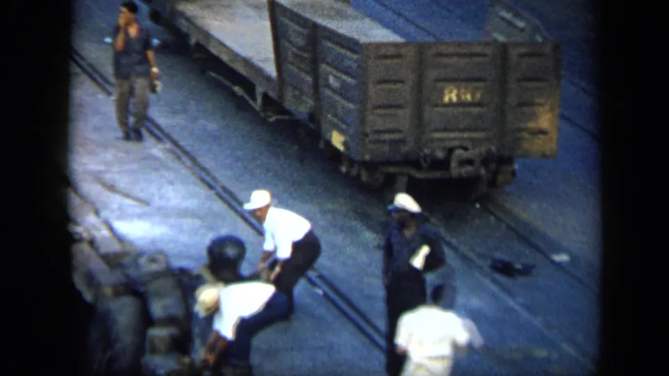 Elevated 8mm view of men working around freight cars and rail lines in a Venezuelan yard in 1959.