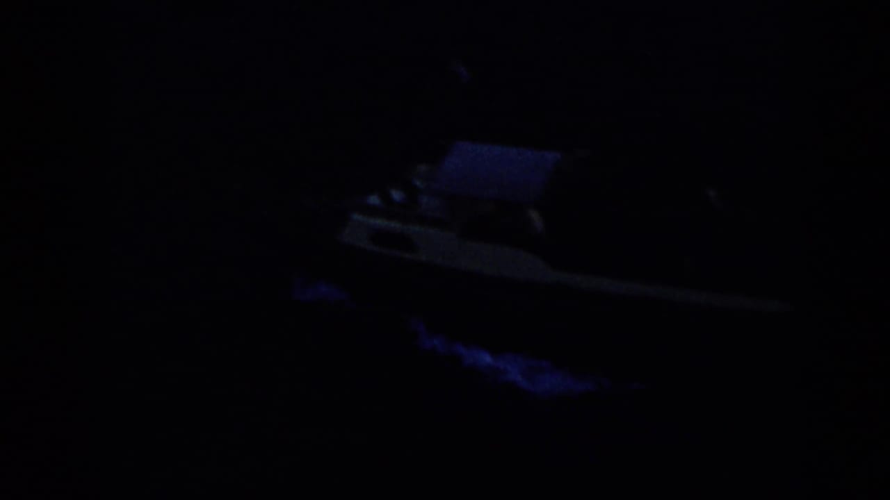 Dark 1959 Venezuela home-movie frame showing a small boat barely visible on night water.