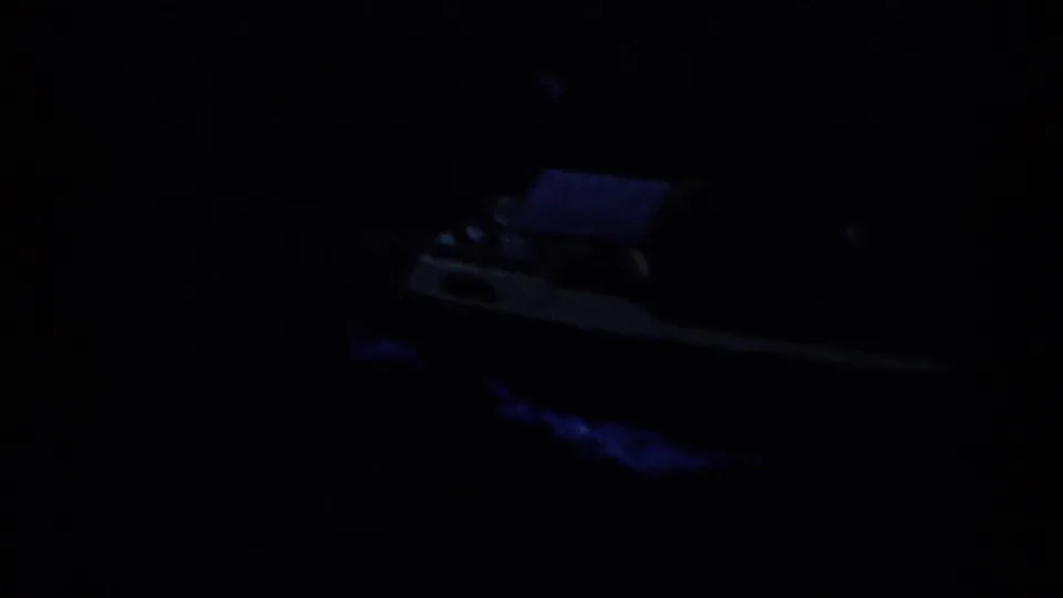 Dark 1959 Venezuela home-movie frame showing a small boat barely visible on night water.