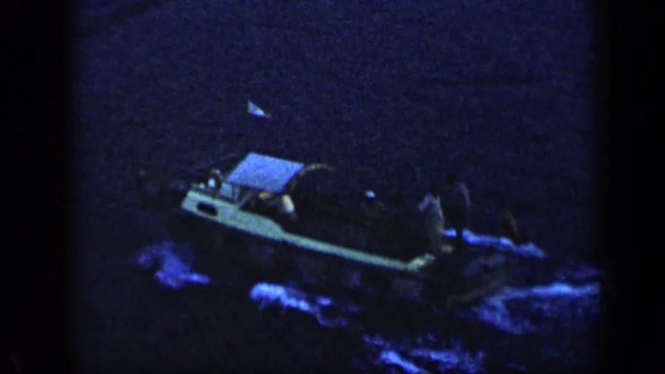 Small motorboat in Venezuela at night, its wake glowing blue as it moves across dark water.