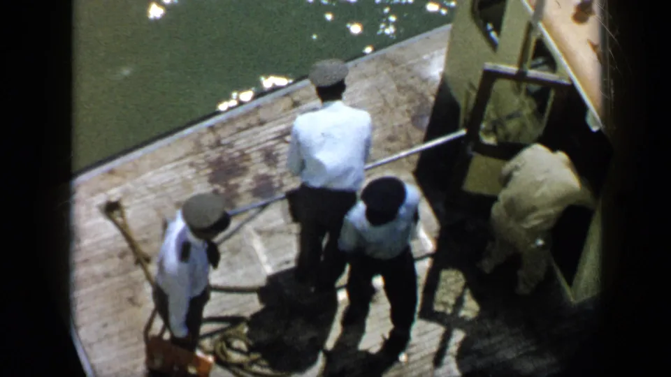1959 Venezuela dock scene showing men beside ropes and a yellow structure, filmed from a high home-movie angle.