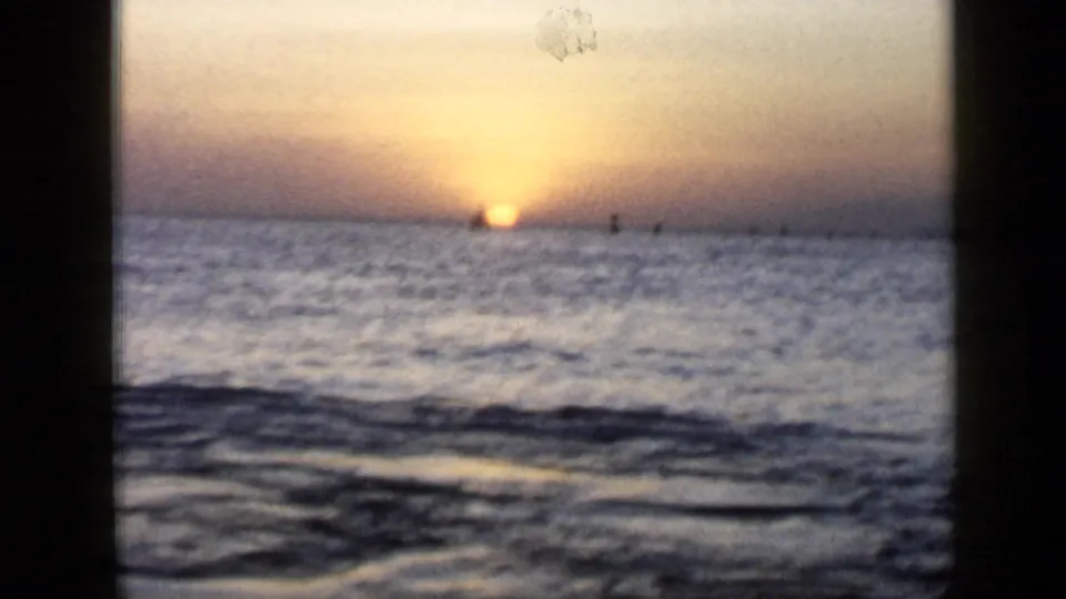 Ocean sunset in the Venezuela travel footage, with the sun touching the horizon and faint silhouettes offshore.