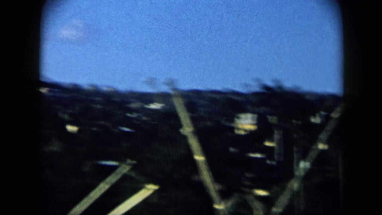 Fast 8mm pan from a boat in Venezuela, with blurred rigging crossing the shoreline and distant hillside.