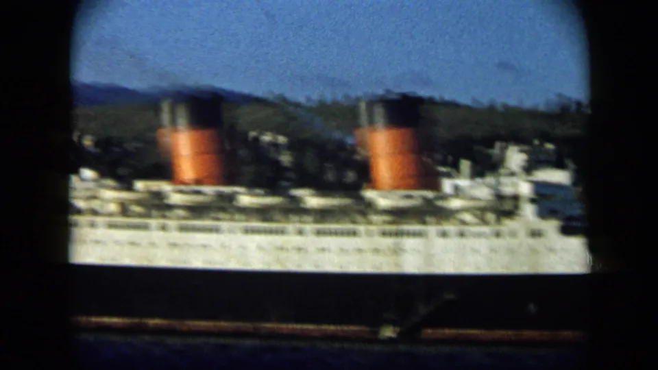 1959 Venezuela 8mm frame showing a large white passenger ship with red-and-black funnels against coastal hills.