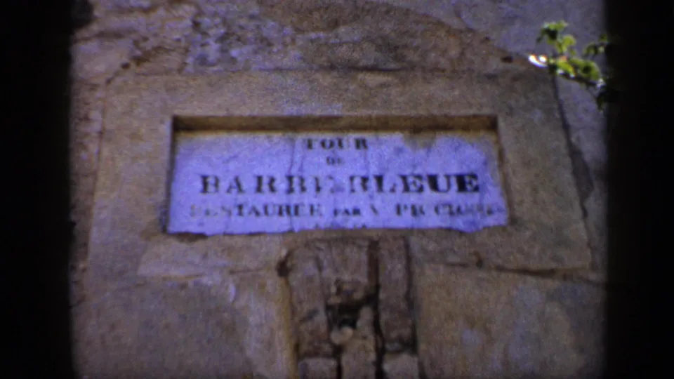 1959 Venezuela 8mm frame showing a weathered wall sign, partly readable as Barquisimeto, with soft focus and dark frame edges.