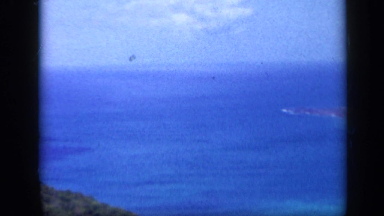 Wide coastal view in Venezuela with blue Caribbean water, sky, shoreline, and a distant island or landform.