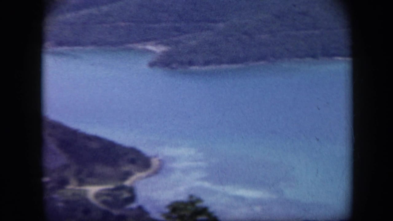 Coastal waterway seen through a dark airplane window frame.