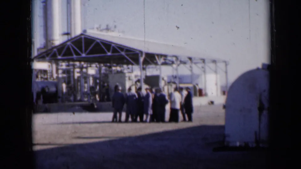 Home-movie view of people outside a large technical-looking structure in 1961 Missouri.