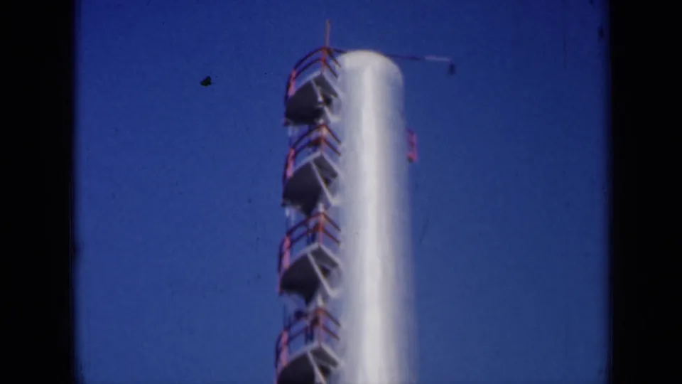 1961 Missouri frame showing a tall cylindrical tower with red railings and metal platforms against clear sky.