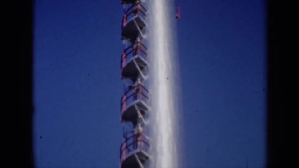 1961 Missouri frame showing a tall white industrial stack with red ladder platforms and dark 8mm frame edges.