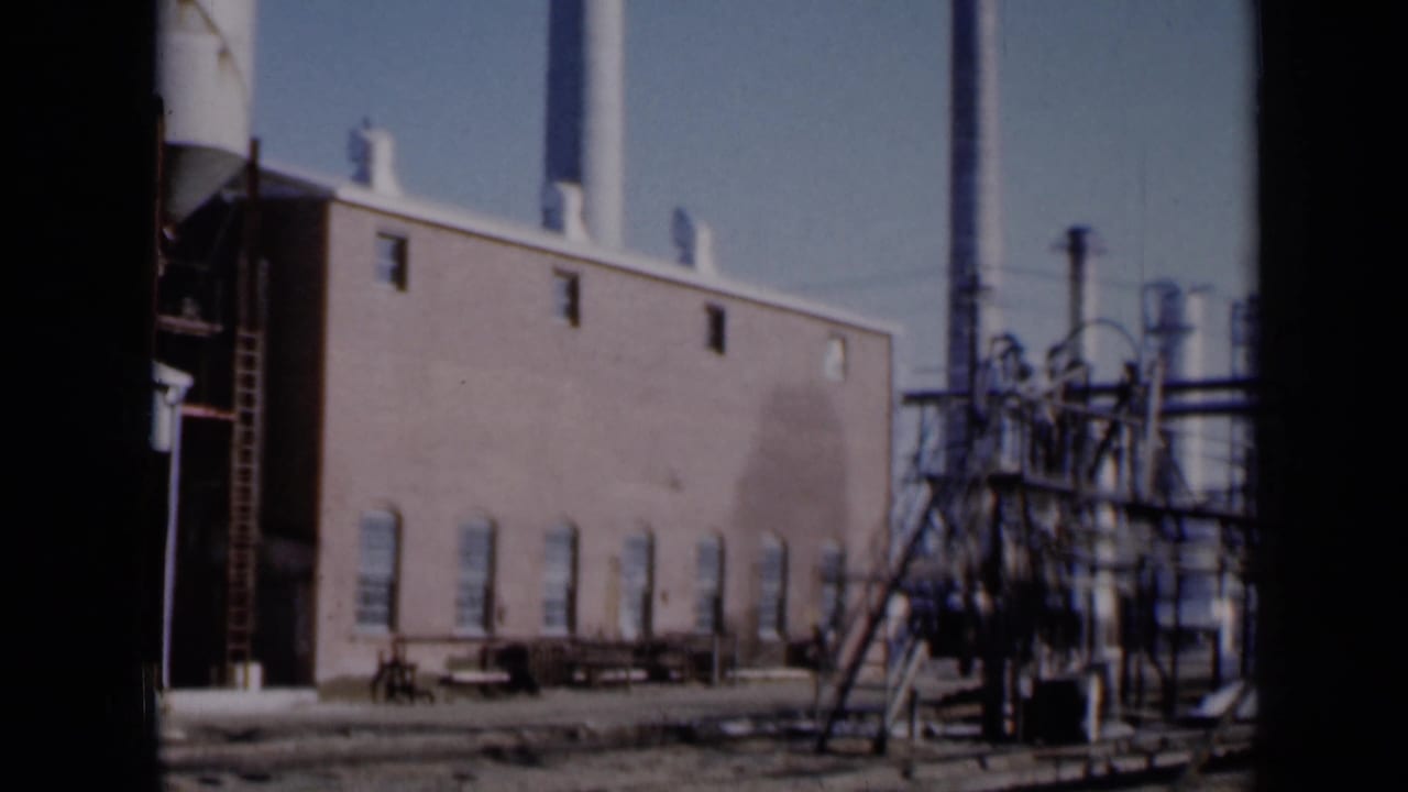 Factory wall, smokestacks, pipes, and metal structures seen from outside.