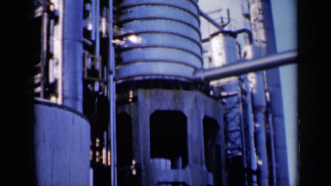 Industrial cylinders, pipes, and a concrete base fill the frame.