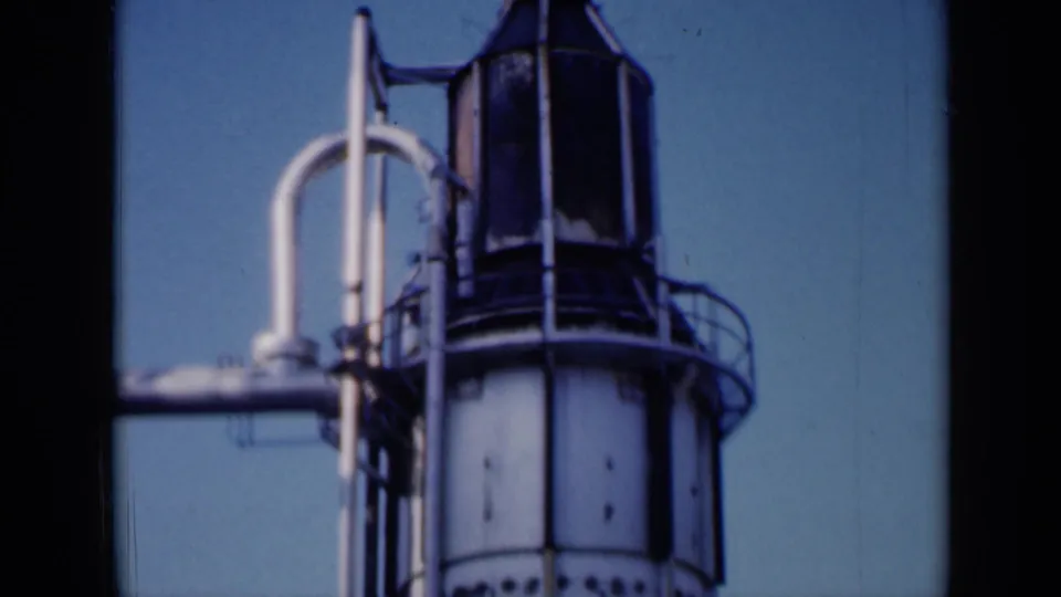 1961 Missouri frame of the tower's upper section, showing curved piping, circular railings and a dark vertical cap in soft 8mm color.