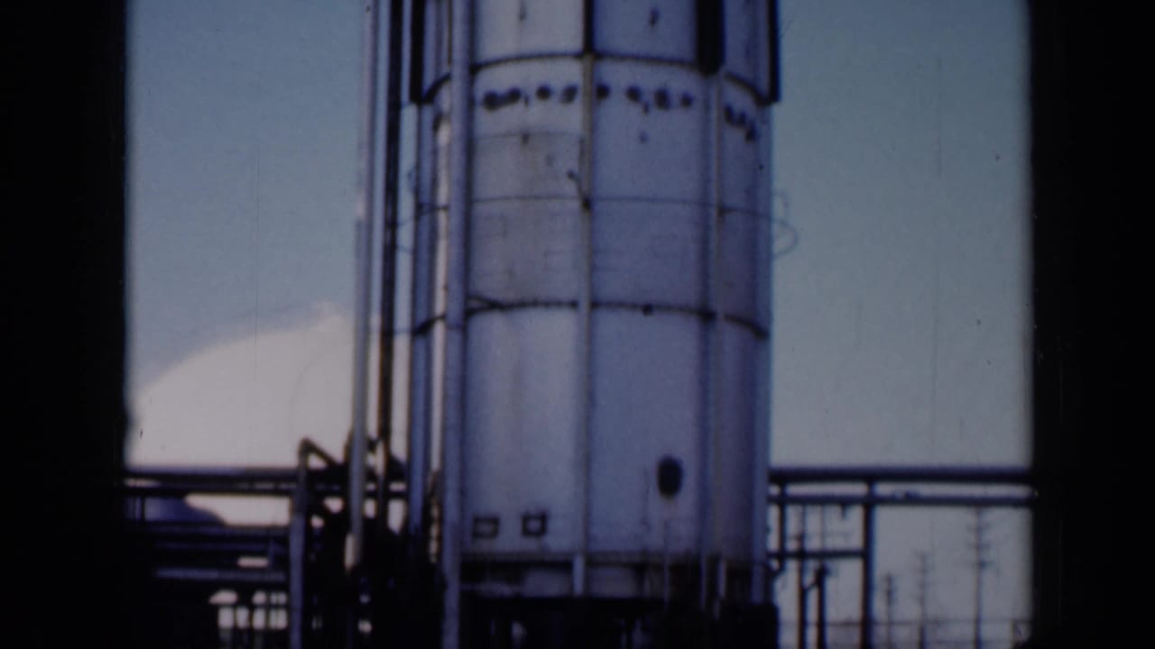 Close view of an industrial tank and platform seen through dark film frame edges.