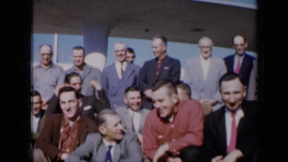 Adult men in 1961 Missouri business and casual shirts sit and stand together during a group photoshoot.