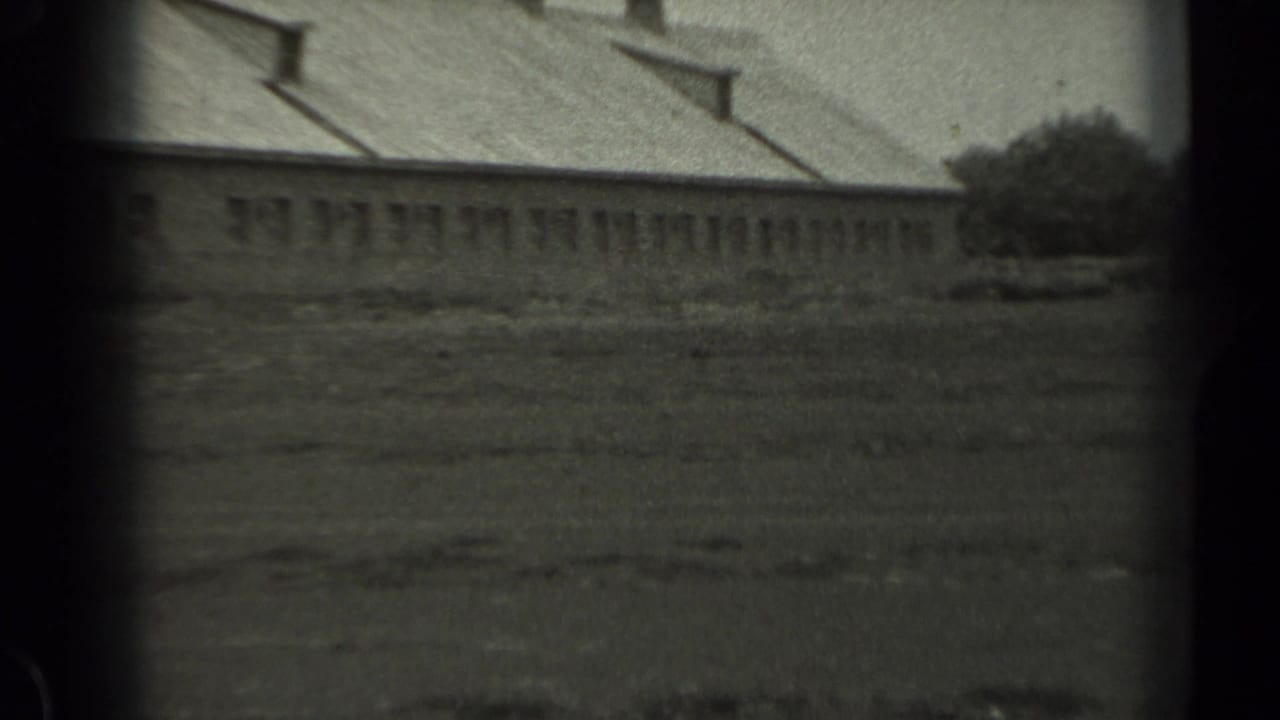 A 1961 Missouri frame centers on a long low rural building with small windows, roof vents, and open ground in front.