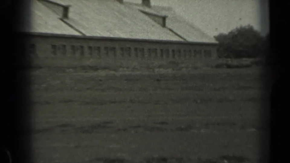 A 1961 Missouri frame centers on a long low rural building with small windows, roof vents, and open ground in front.