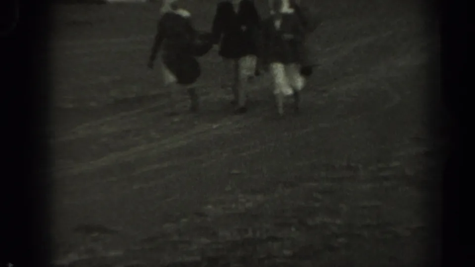 The women are closer in frame, with headscarves, handbags, and light skirts visible as they walk in 1961 Missouri footage.