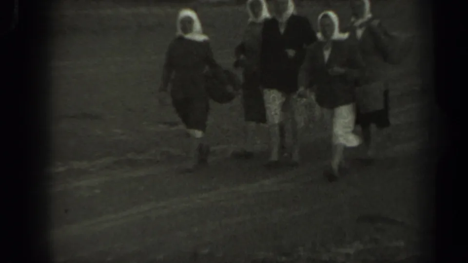 1961 Missouri 8mm still with three women in white head coverings and dark dresses walking toward the camera outdoors.