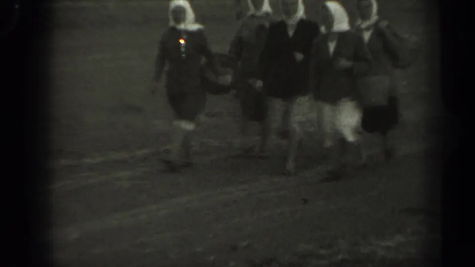 In Missouri, 1961, several passengers appear to walk near the airport area in grainy 8mm black-and-white footage.