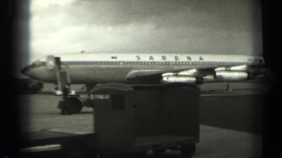 The 1961 Missouri home-movie view shows the Sabena aircraft side-on, with stairs and ground equipment visible below the fuselage.