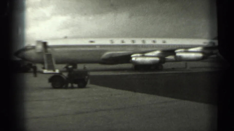 1961 Missouri airport footage showing a Sabena jetliner parked on the tarmac with mobile stairs and ground support equipment visible.