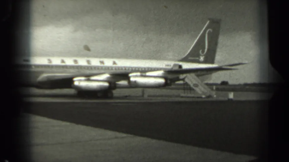 1961 Missouri home-movie frame showing the rear section of a Sabena jetliner, tail branding, engine pods, and nearby mobile stairs.