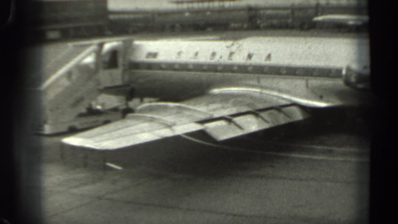 Parked Sabena airplane seen through dark vertical window framing at the airport ramp.