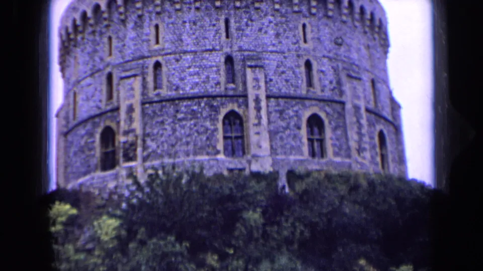 Low-angle visitor-shot view of the castle tower in England, softened by 8mm grain and color shift.