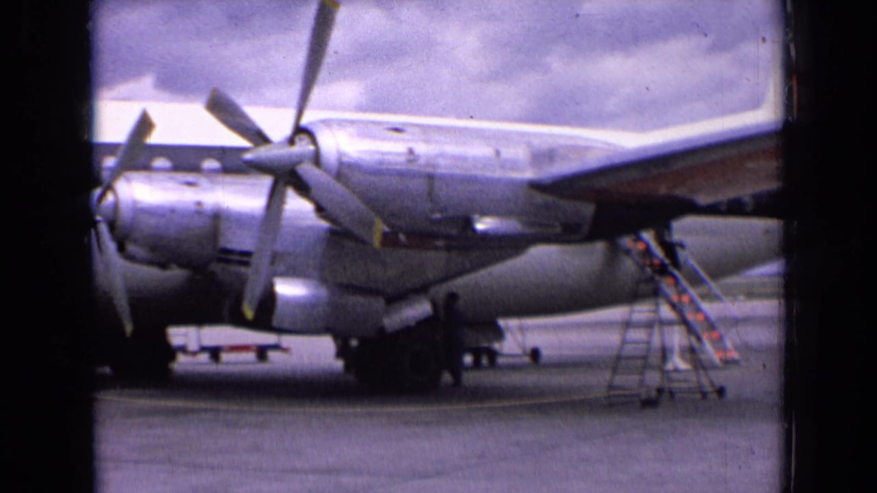 Silver BEA propeller plane on an airport apron with mobile stairs nearby.