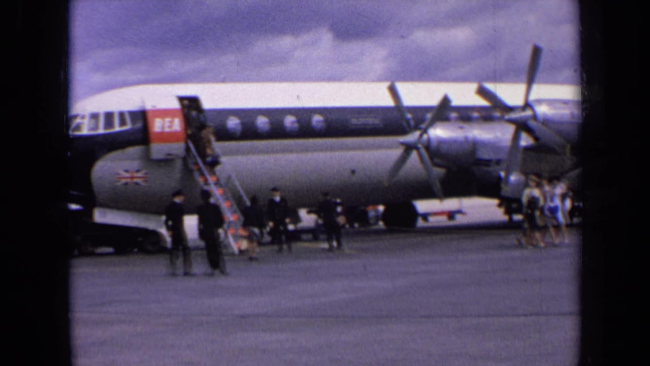 1963 England home-movie view of passengers and staff gathered near a BEA propeller aircraft as boarding stairs reach the forward door.
