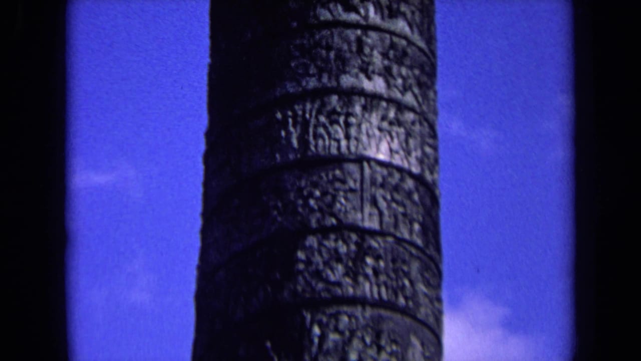 Tall column section with carved bands seen against blue sky.