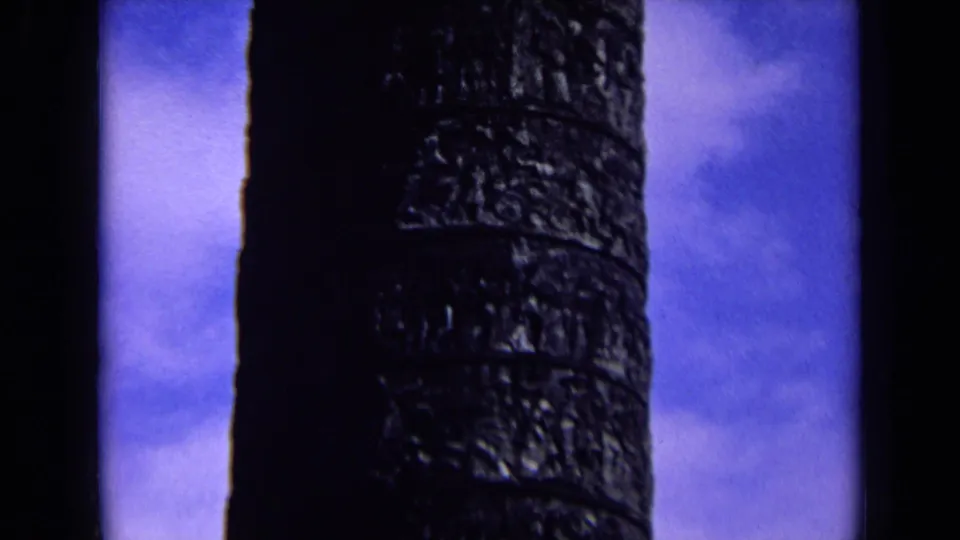 Final 1963 England frame with the carved column in darker exposure, set against blue sky and scattered cloud.