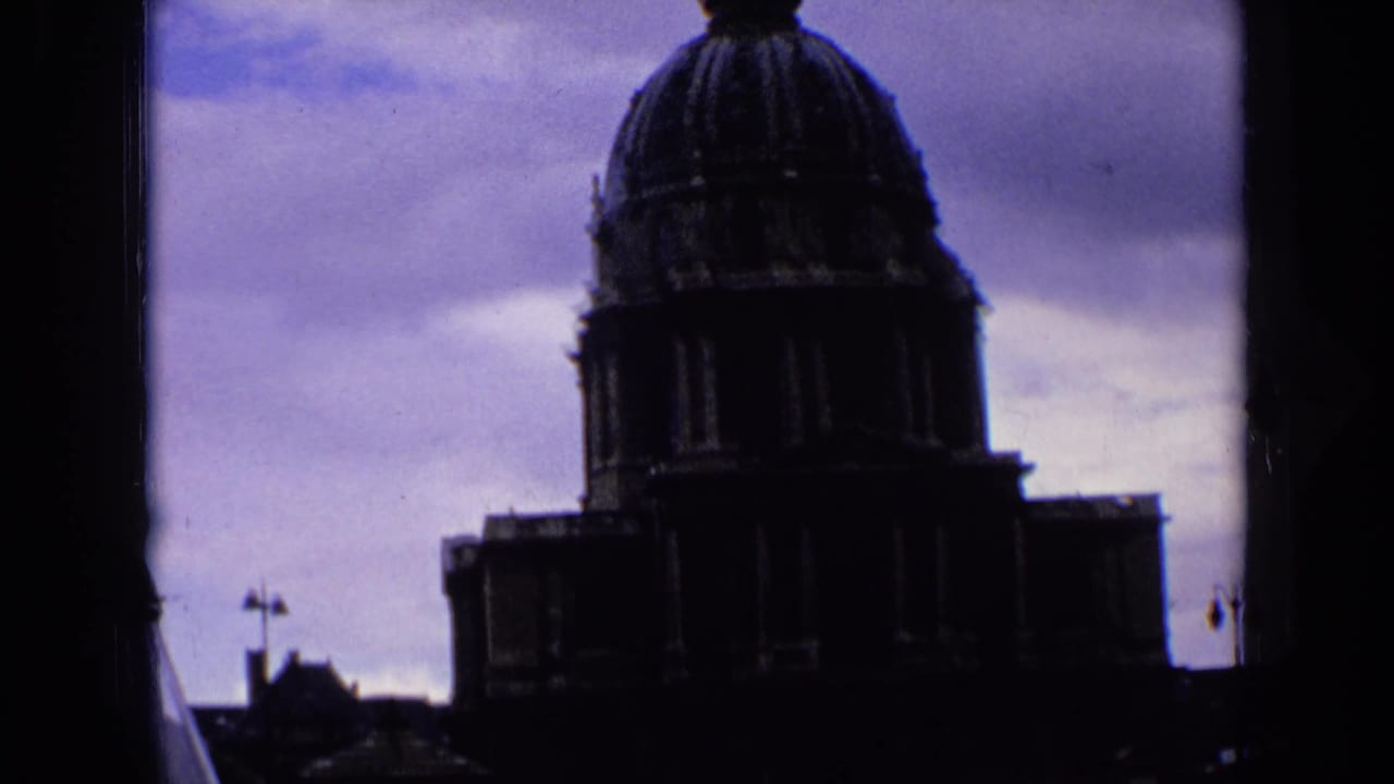 Silhouetted church dome and cross-topped steeple against a cloudy sky.