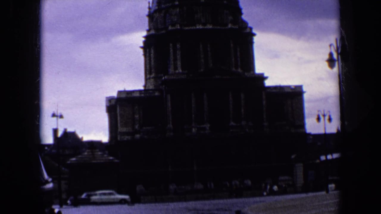 Shadowed monumental building with street and cars below.
