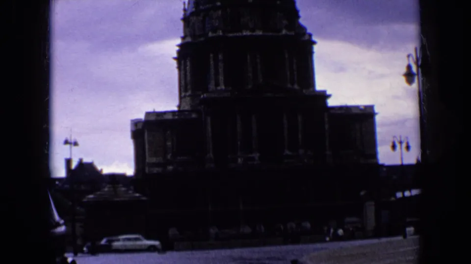 Shadowed exterior view of a large French landmark with cars and street details visible near the base.