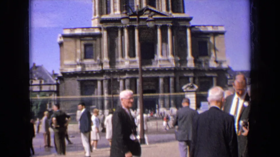 Brighter 1963 France frame showing a columned landmark facade and pedestrians in mid-century clothing.