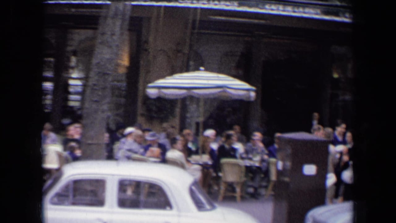Outdoor cafe with seated patrons, striped umbrella, pedestrians, and a white vintage car in front.