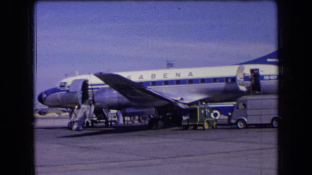 Sabena aircraft beside mobile stairs and ground service vehicles on the airport apron.
