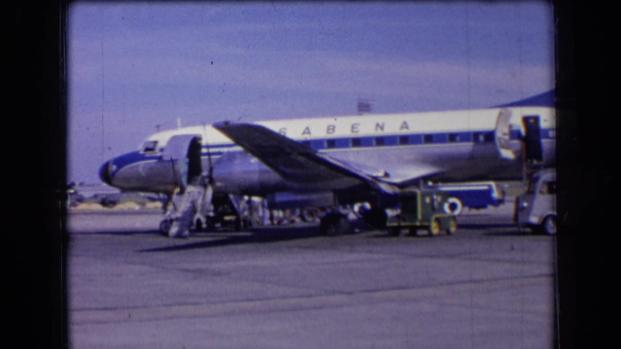 Sabena propeller airliner on a tarmac with boarding stairs and ground equipment.