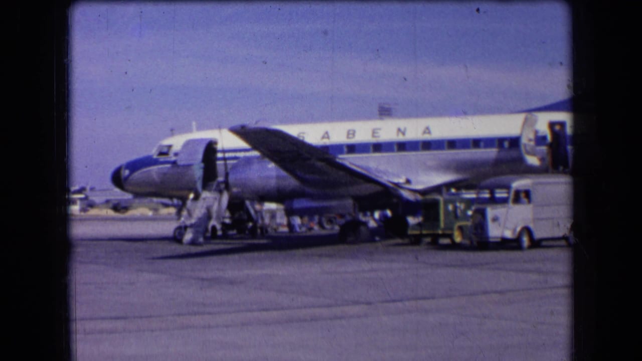 Sabena aircraft beside a service vehicle and boarding stairs on the airport apron.