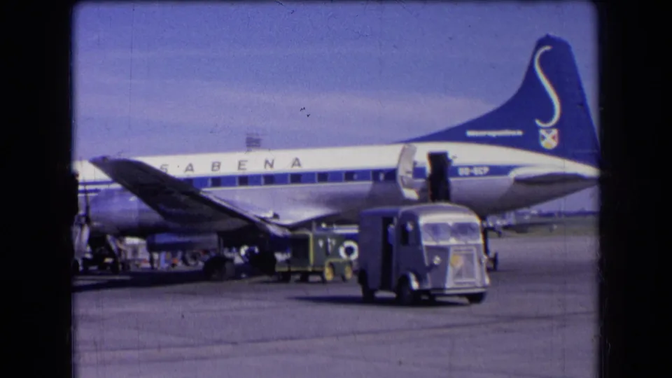 Sabena aircraft tail and fuselage are visible on a French airport tarmac in 1963, with service vehicles and boarding stairs nearby.