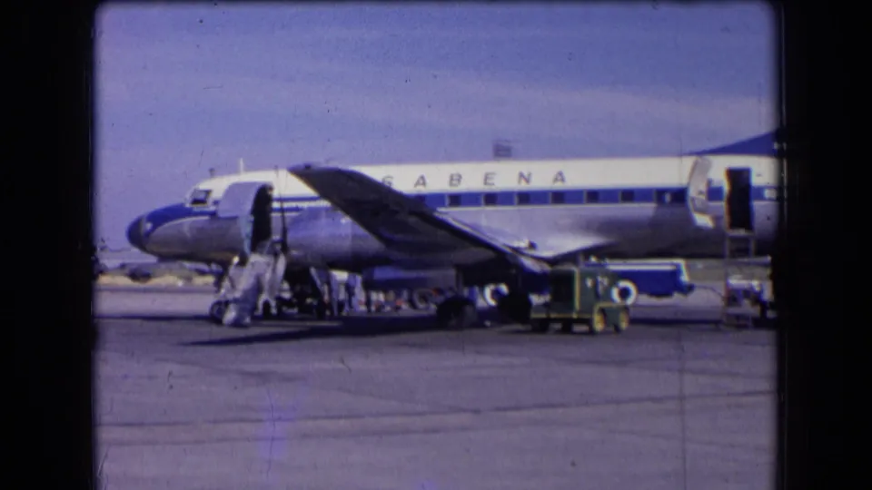 1963 France tarmac scene showing a Sabena aircraft, wing, portable stairs, baggage cart, and crew working beside the plane.