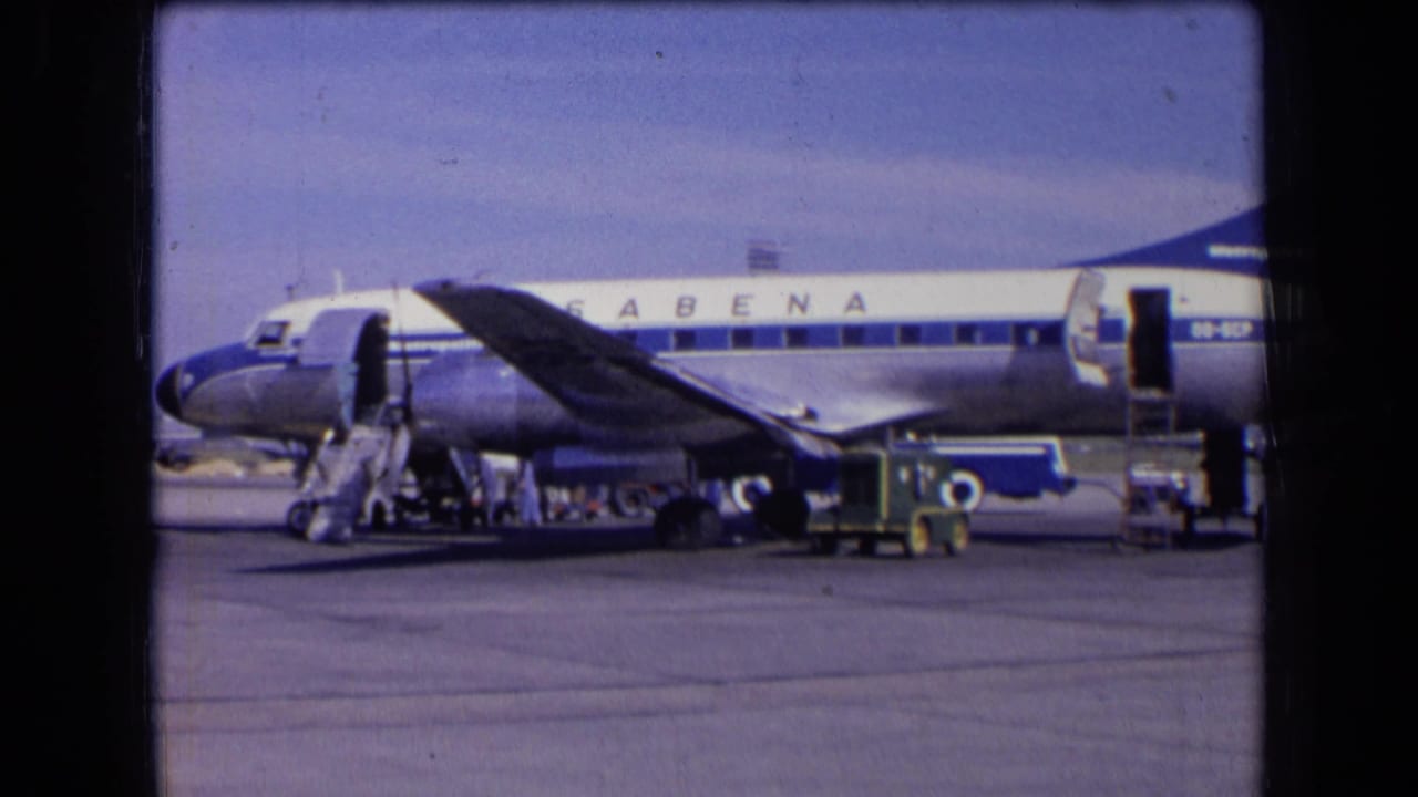 Sabena passenger plane on an airport apron with stairs and service equipment nearby.