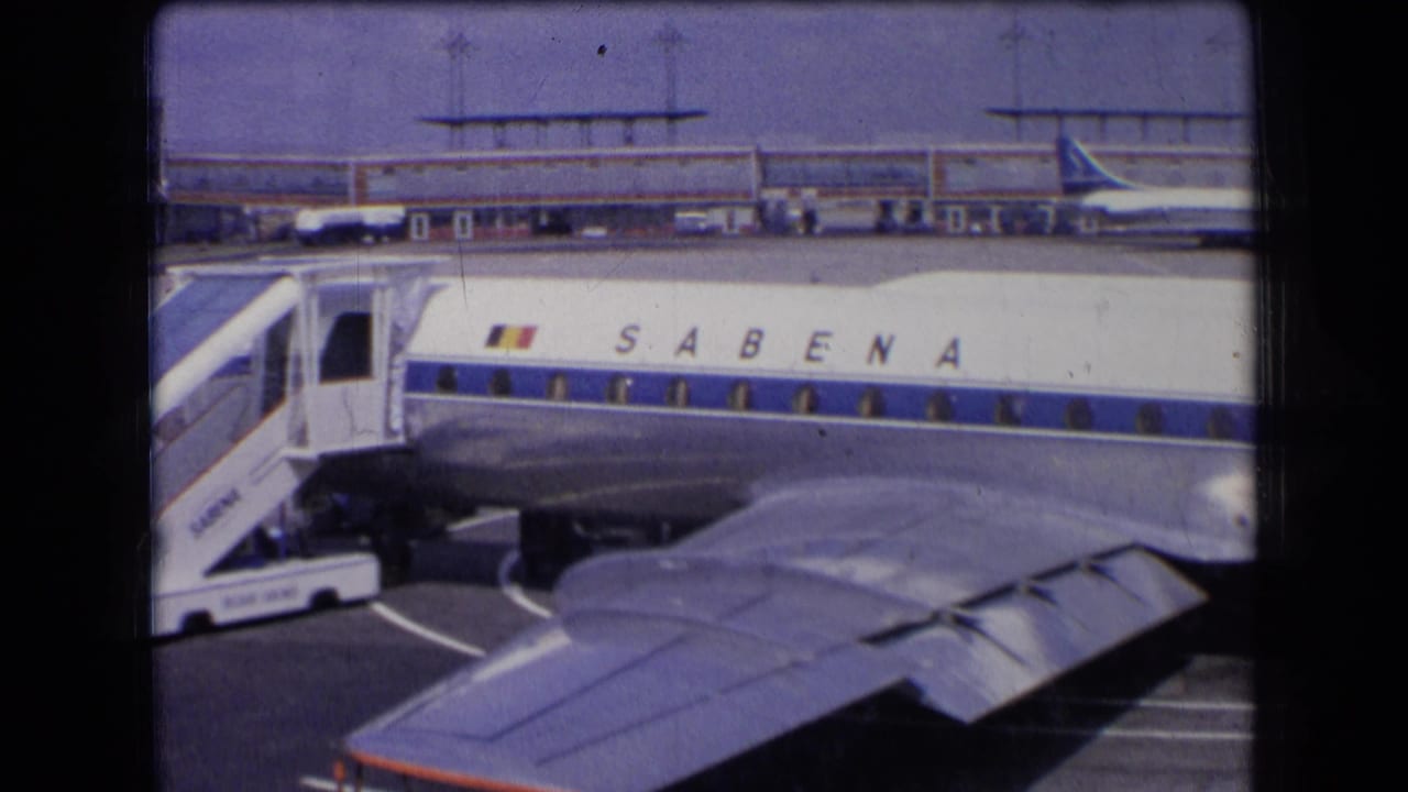 1963 France frame with Sabena lettering visible on a parked aircraft beside boarding stairs and a terminal building.