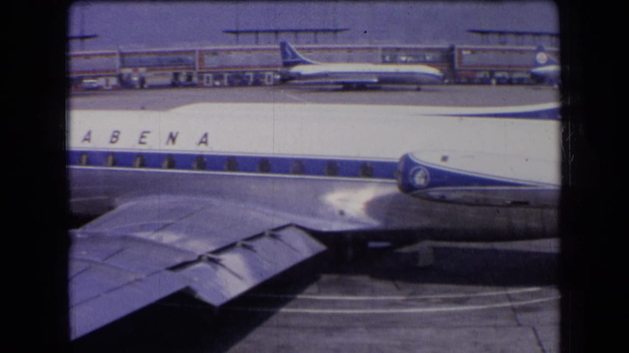 1963 France airport view of a Sabena airliner passing close to the camera, with its wing, engines, and terminal-side aircraft visible.