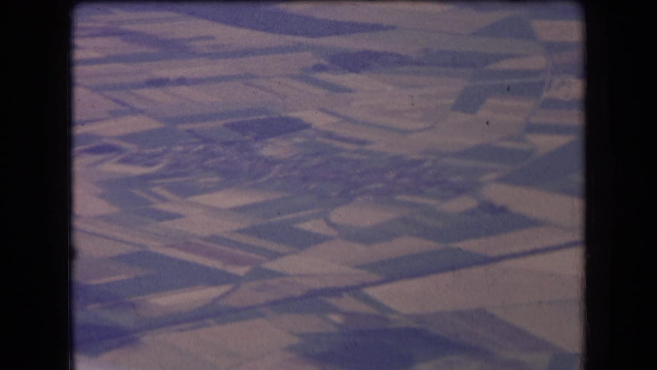 1963 France aerial view of geometric farm plots and field boundaries, rendered in faded blue-purple 8mm color.