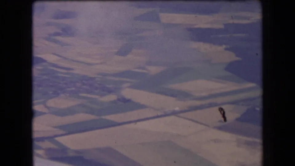 1963 France aerial frame showing divided farm plots and pale fields, with visible film wear or debris near the lower right.